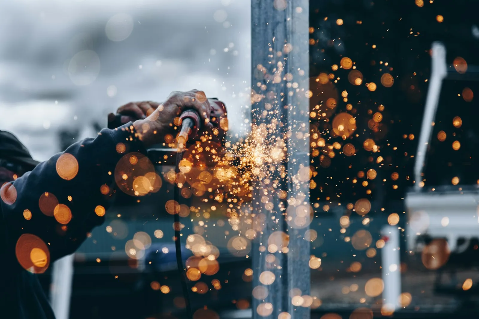 Steel fabrication worker grinding a fabricated beam in a workshop