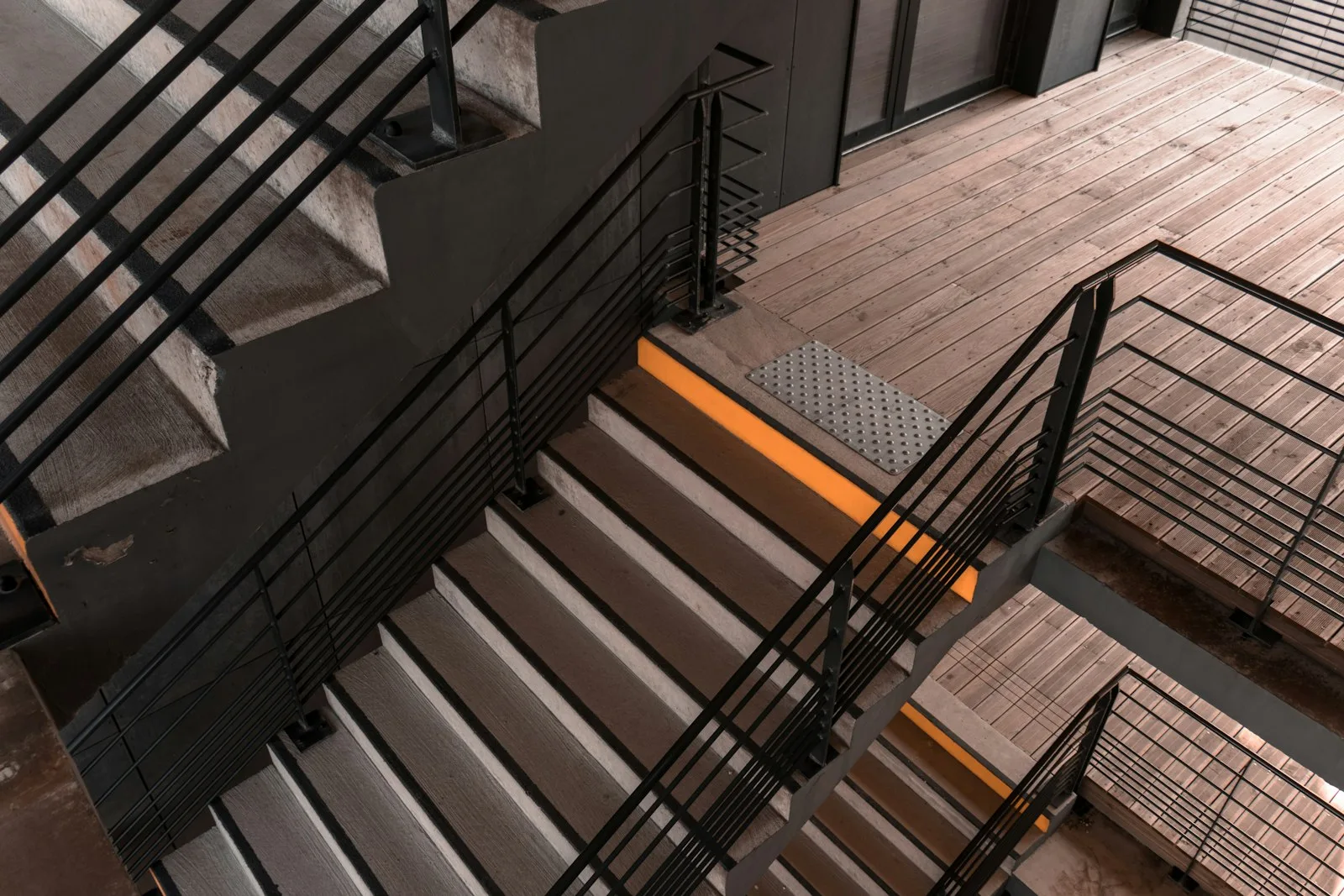Welded steel staircase rails crossing a concrete staircase
