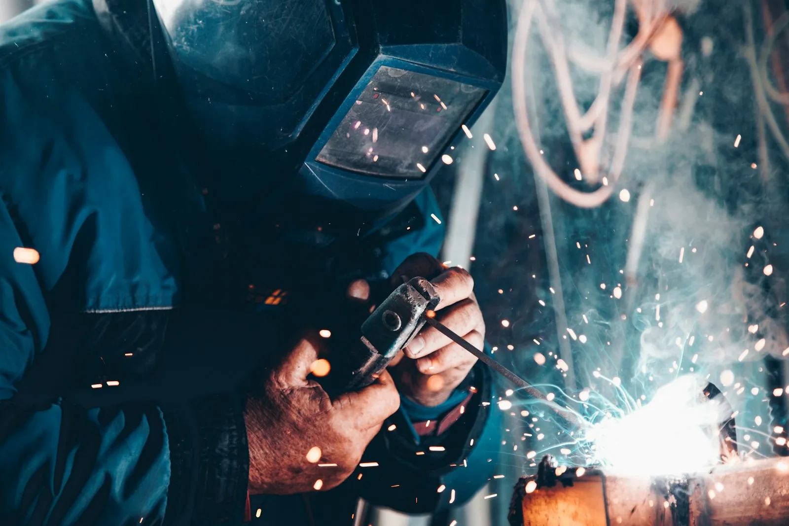 Welder making a steel assembly with sparks in a workshop