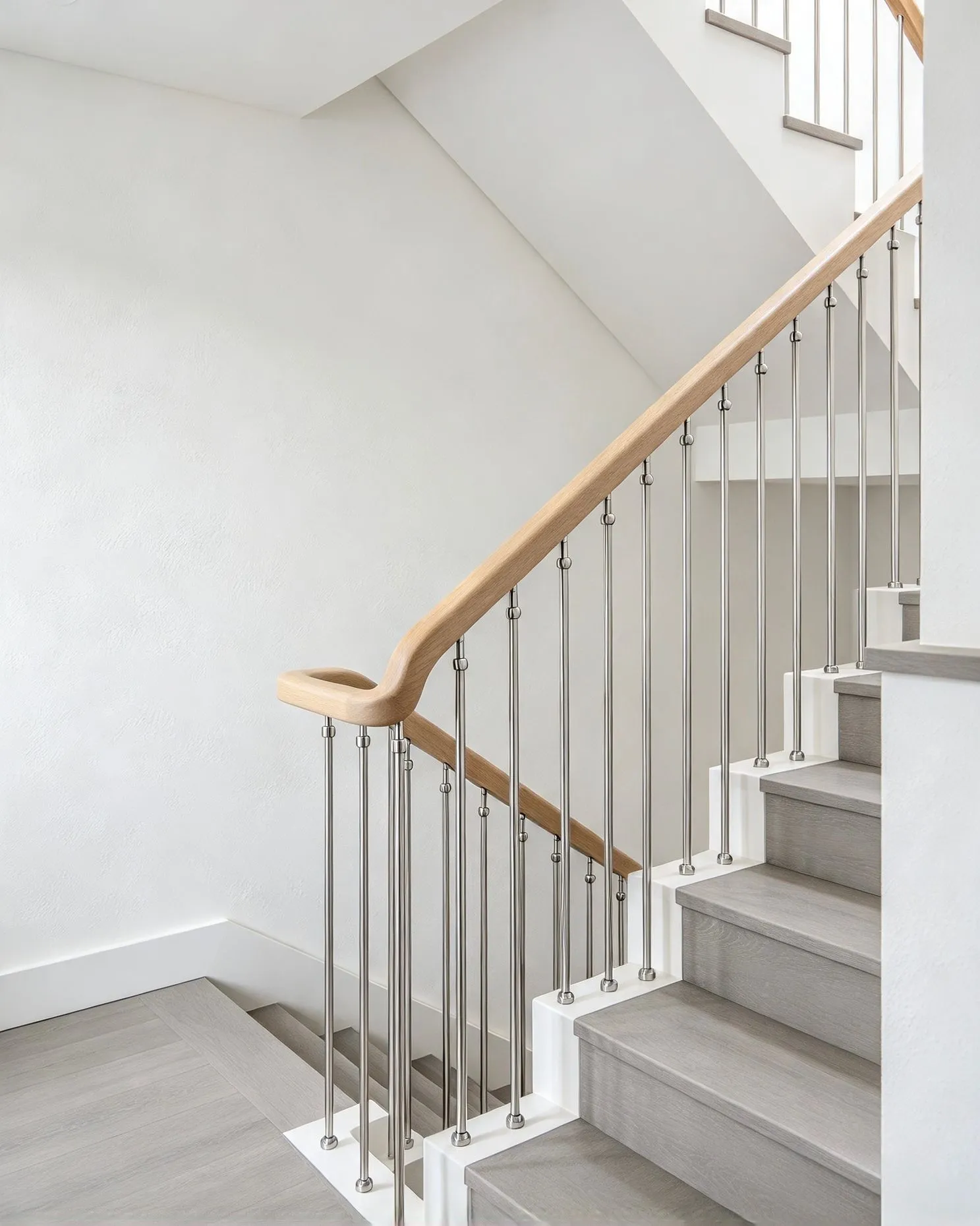 Brushed stainless steel balusters and timber handrail fitted to a modern staircase